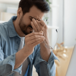 Man rubbing his temples with a stressed expression.