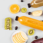 Assorted fresh fruits and juices arranged on a light background.