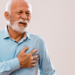 Older man holding his chest with a pained expression.