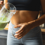 Person holding a green smoothie.