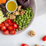 A colorful salad bowl with cherry tomatoes, green peas, and other vegetables.