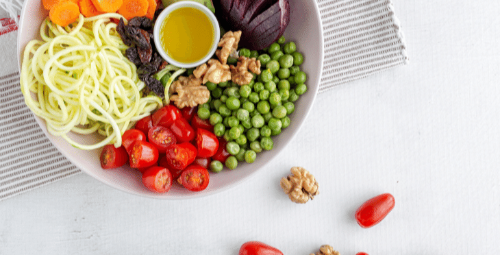 A colorful salad bowl with cherry tomatoes, green peas, and other vegetables.