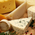 Assorted cheeses, including blue and yellow varieties.-