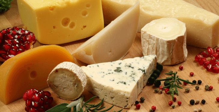 Assorted cheeses, including blue and yellow varieties.-