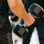 Person lifting dumbbells during a workout.