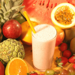 Fresh fruit and a smoothie on a table.