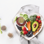 Bowl of healthy food including avocado, berries, and seeds.
