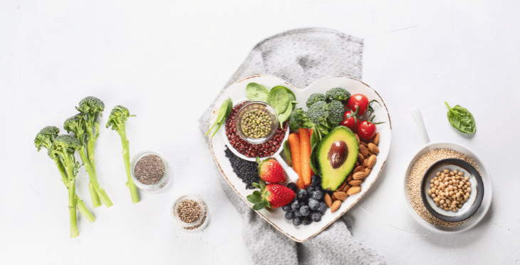 Bowl of healthy food including avocado, berries, and seeds.
