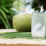 Green apple and glass of water on a table.
