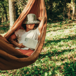Woman reading in a hammock outdoors.