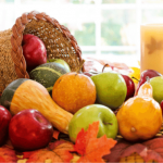 Basket of fresh fruit with fall leaves.