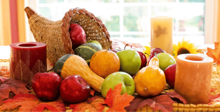 Basket of fresh fruit with fall leaves.