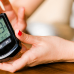 Close-up of a person checking their blood sugar with a meter.