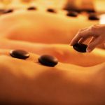 Spa stones on a person’s back during a massage.