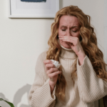 Woman with a tissue, appearing to have a cold.