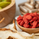 Dried goji berries in a bowl with ginger and lemon.