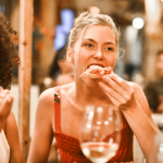 Women enjoying food and wine in a social setting.