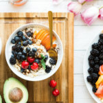 Bowl of yogurt topped with fresh berries and granola.
