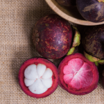 Close-up of mangosteen fruit and its purple rind.
