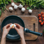 Person cracking an egg over a frying pan.