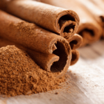 Rolled cinnamon sticks and ground cinnamon on a wooden background.