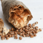 Loaf of rustic bread with scattered seeds on a white background.